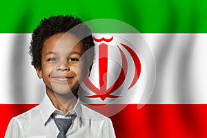 Irani kid boy on flag of Iran background. Education and childhood concept photo