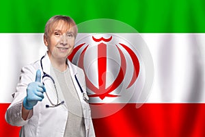 Irani smiling mature doctor woman holding stethoscope on flag of Irani background photo