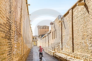 An Iranian boy rinding bicycle in the lane in the old town of Shiraz, Iran