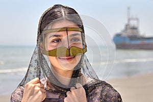 Iranian girl in traditional Muslim mask of southern Iran, smiling.