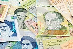 Iranian Rial and Venezuelan Bolivar hyperinflation banknotes. photo