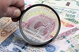 Iraqi dinar in a magnifying glass