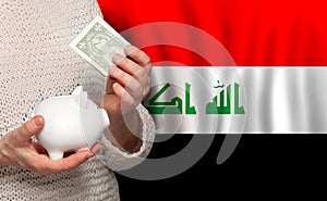 Iraqi woman with money bank on the background of Iraq flag. Dotations, pension fund, poverty, wealth, retirement concept