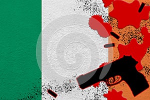 Ireland flag and black firearm in red blood. Concept for terror attack or military operations with lethal outcome