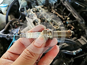 Iridium car spark plug in the mechanic hand