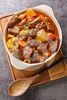 Irish Beef and Guinness Stew with seasonal vegetables closeup in the pot. Vertical top view photo
