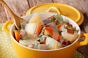 Irish coddle with pork sausage, bacon and vegetables close-up.