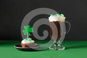 Irish coffee in glass cup and special cupcake for St Patrick s Day.