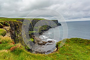 Irish countryside and rocky cliffs along the coastal walk route from Doolin to the Cliffs of Moher