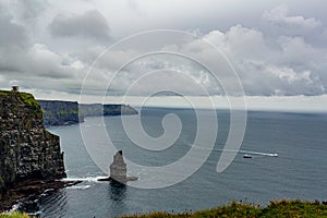 Irish landscape of the Branaunmore sea stack and two boats sailing in the ocean on the Cliffs of Moher