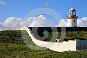 Irish Lighthouse on a green hill photo
