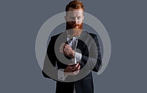 Irish man adjusting cuffs. Bearded man wearing tuxedo. Businessman with beard in formalwear