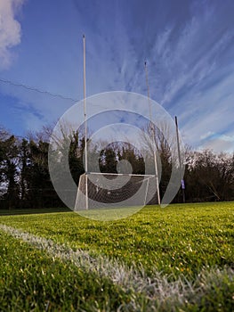 Irish National sport goal posts on a green grass training pitch.