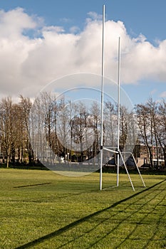 Irish National sport tall goal post on a training ground. Camogie, hurling, rugby, gaelic football pitch. Warm sunny day, Cloudy