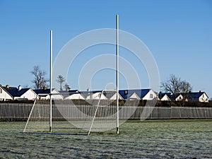 Irish sport training ground with tall goal posts for camogie, Gaelic football and rugby on a cold winter day. Frost on the green