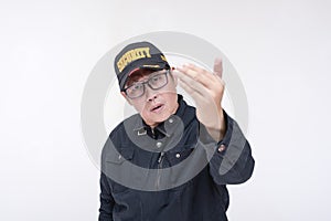 An irked male security guard challenges someone to come closer. Commanding gesture with palm. Isolated on a white background
