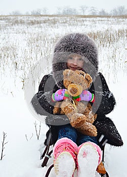 Irl in a fur coat and hat on a sledge with