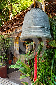 Iron bell with local bamboo house
