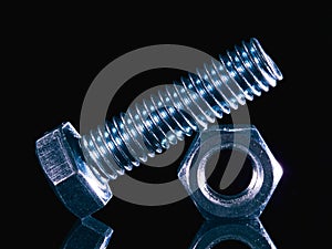 Iron bolt and nut on black background with reflexion