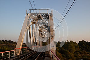 Iron bridge against the green forest