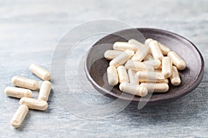 Iron capsules. Concept for a healthy dietary supplementation. Bright wooden background.