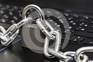 an iron chain fastened with a padlock on a computer keyboard the concept of data protection censorship on the Internet