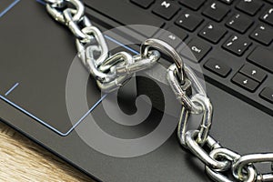 an iron chain fastened with a padlock on a computer keyboard the concept of data protection censorship on the Internet