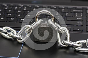 an iron chain fastened with a padlock on a computer keyboard the concept of data protection censorship on the Internet