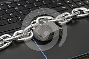 an iron chain fastened with a padlock on a computer keyboard the concept of data protection censorship on the Internet