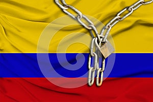 Iron chain and lock on Colombia silk national flag with beautiful folds, the concept of a ban on tourism, political repression,