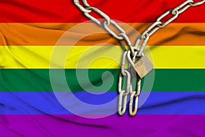 Iron chain and lock on the LGBT rainbow flag, Pride flag with beautiful folds, the concept of a ban on tourism, political