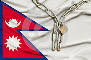 Iron chain and lock on Nepal silk national flag with beautiful folds, the concept of a ban on tourism, political repression, crime
