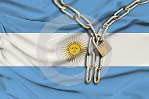 Iron chain and lock on the silk national flag of Argentina with beautiful folds, the concept of a ban on tourism, political