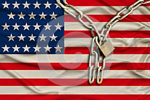 Iron chain and lock on usa silk national flag with beautiful folds, the concept of a ban on tourism, political repression, crime,