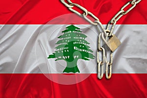 Iron chain, a symbol of bondage,protest against the background of national flag Lebanon, the concept of political repression,