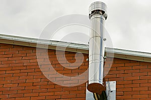 Iron chimney from the fireplace to heat a house with copy space on the roof background