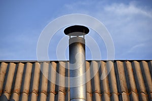 Iron chimney on the roof of the house