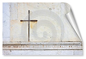 Iron Christian cross snuggled against a white stone on a italian facade church - curl and shadow design concept image with copy