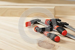 Iron clamps. Clamps and vices. Wooden bars on workshop table