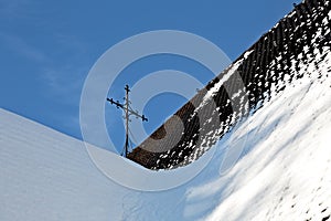 An iron cross on the shingle roof