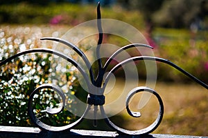 Iron decorations atop a garden gate.