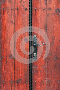 Iron door handle on old rustic wooden door outdoor shot close