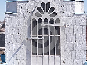 Iron door to a white stone mausoleum