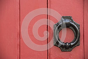 Iron doorknocker on red doors