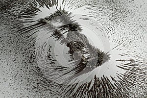 Iron dust showing the magnetic field near a magnet bar on white background