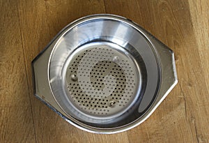 Iron empty colander on wooden background