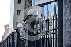 Iron fence with pins and lanterns in the city