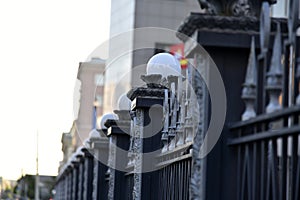 Iron fence with pins and lanterns in the city