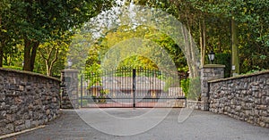 Iron front gate of a luxury home. Wrought iron gate and brick pillar. Nobody, street photo