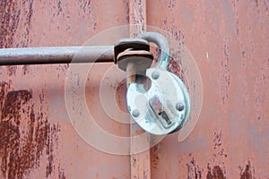 Iron gate covered with rust and a large lock on the gate. texture of a metal door